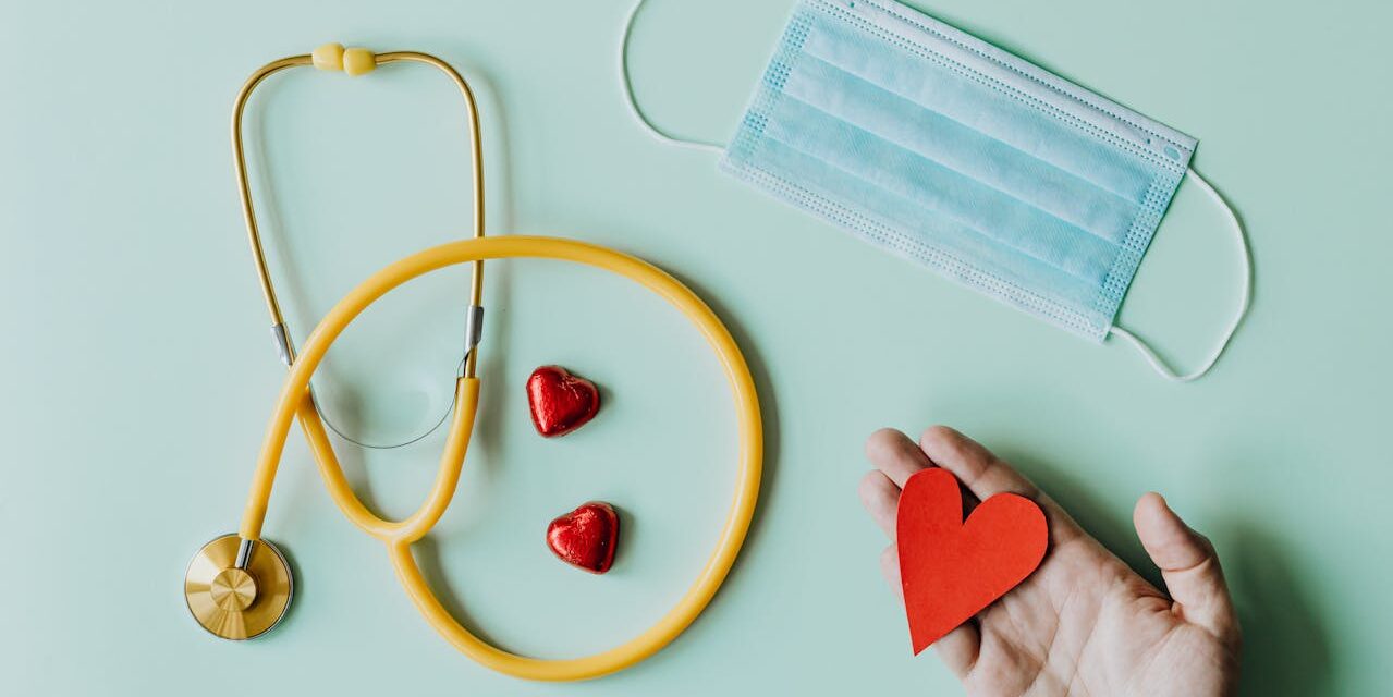 Stéthoscope, masque médical et cœurs rouges sur fond bleu